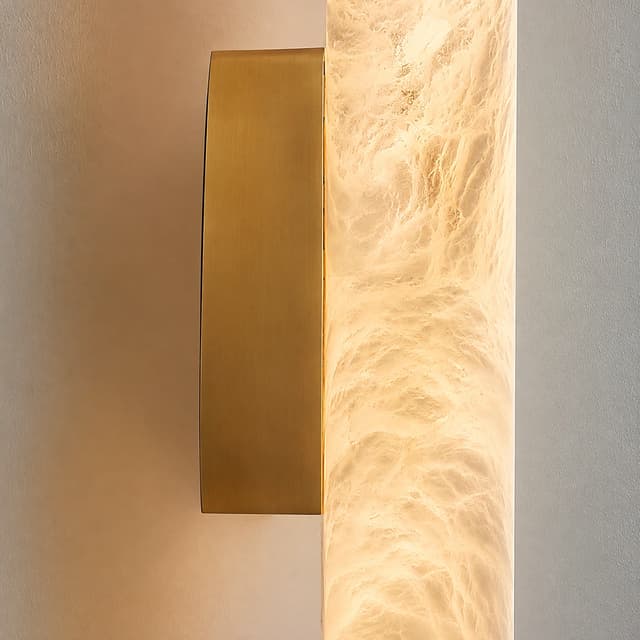 Close up of brass wall plate and illuminated marble veined cylinder diffuser