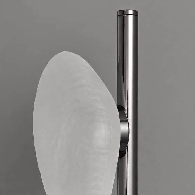 Close up of frosted textured glass shade and polished black metal frame on modern wall light