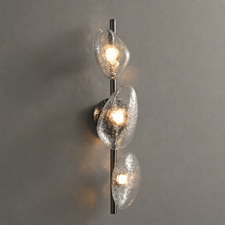 Three light clear textured glass wall sconce with organic pebble shades and warm illumination