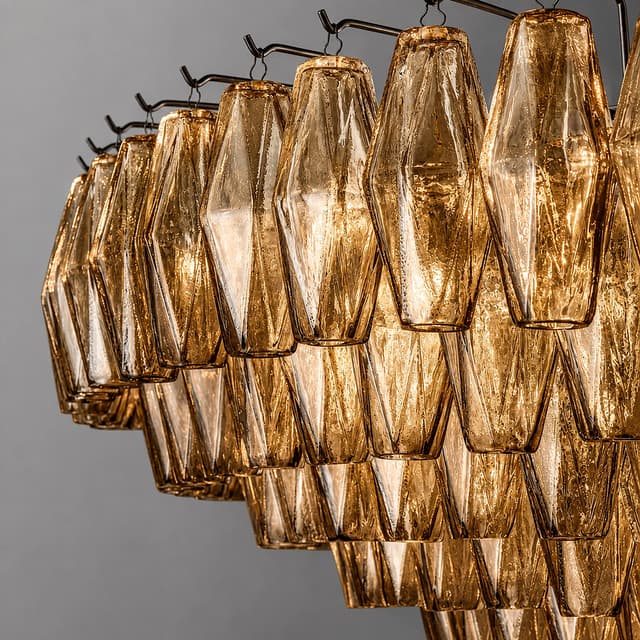 Close up of textured amber glass chandelier pendants with faceted surfaces and individual