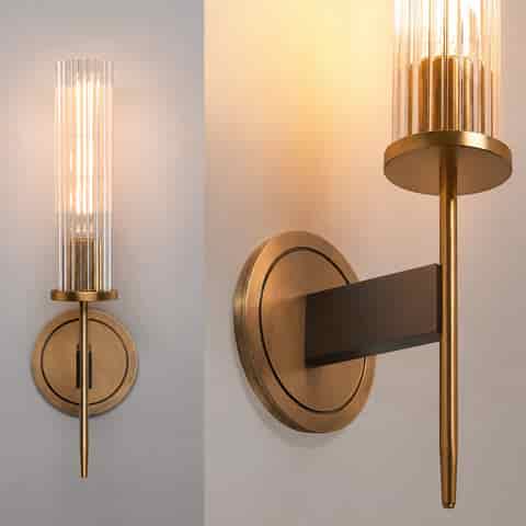 Gold finish copper wall sconce with clear fluted glass and round backplate