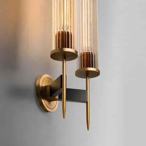 Close up of two light fluted glass and copper wall sconce with gold finish