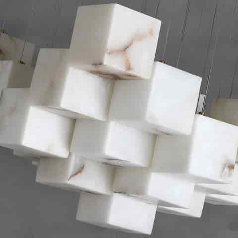 Close up of white marble cube chandelier shades with natural looking veining and suspended cables