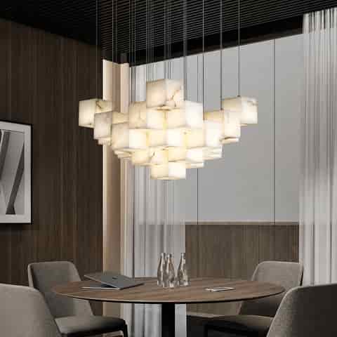 Marble cube cluster chandelier above a modern round dining table with warm ambient lighting