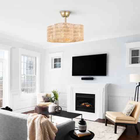 Boho woven fandelier ceiling fan with gold finish installed in a bright living room