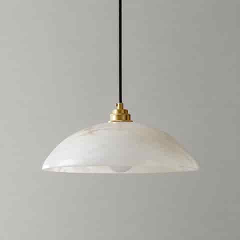 White alabaster dome pendant light with natural veining, brass tone socket and black suspension cord