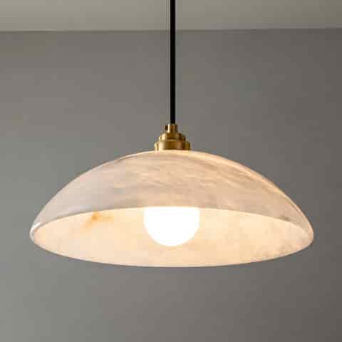 Close up of illuminated alabaster dome pendant showing translucent natural stone veining