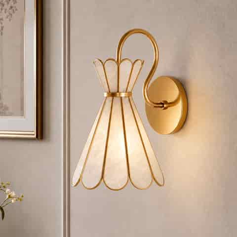 Close up of a gold shell wall sconce with luminous textured natural shell panels and sculptural metal framing