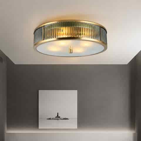 Copper and fluted glass drum flush mount ceiling light in a warm modern interior
