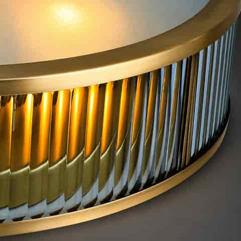 Close up of copper frame and fluted glass detailing on a luxury flush mount ceiling light