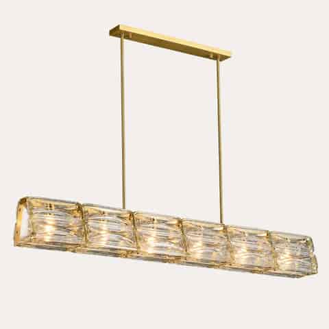Gold copper and clear textured glass linear chandelier glowing warmly against a dark background 150cm