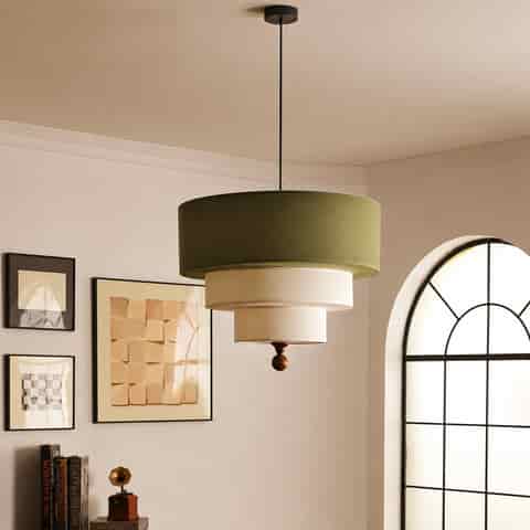 Three tier fabric drum pendant light with olive green and cream shades in a warm modern interior