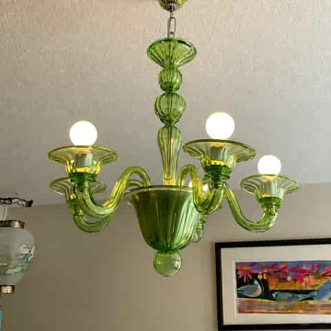 Green glass chandelier with eight curved arms and decorative center column