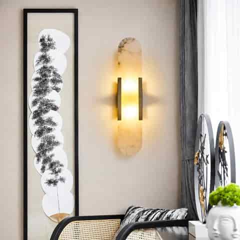 Gold natural alabaster wall sconce glowing in a modern living room
