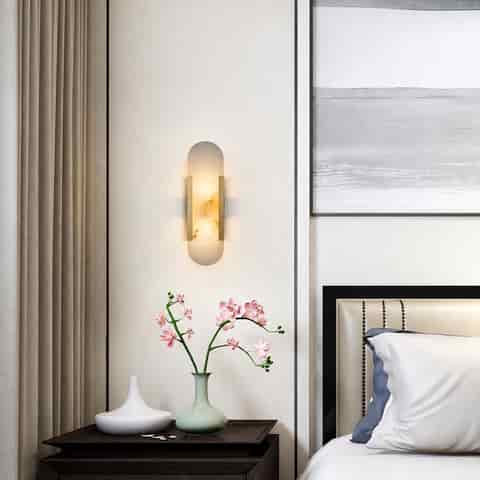 Vertical natural alabaster wall sconce beside a modern bedroom nightstand