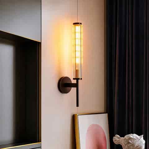 Black fluted glass and copper wall sconce installed beside a modern bed