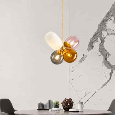 Colorful glass globe chandelier with pink, amber, smoke gray and white shades above a modern dining table