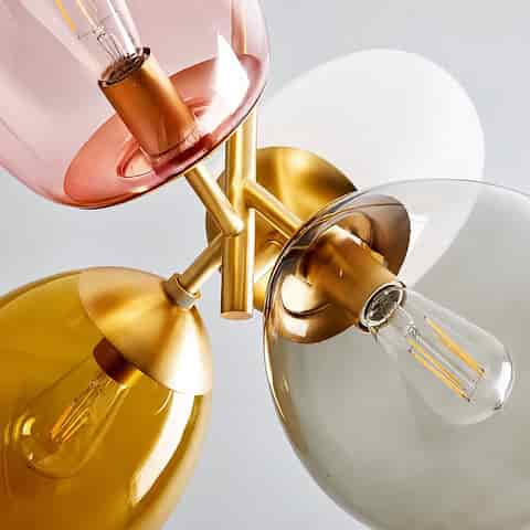 Close up of multicolor glass shades and gold tone metal frame on a modern 4 light chandelier