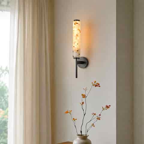 Blackened brass terrazzo wall sconce with warm 3000K ambient light