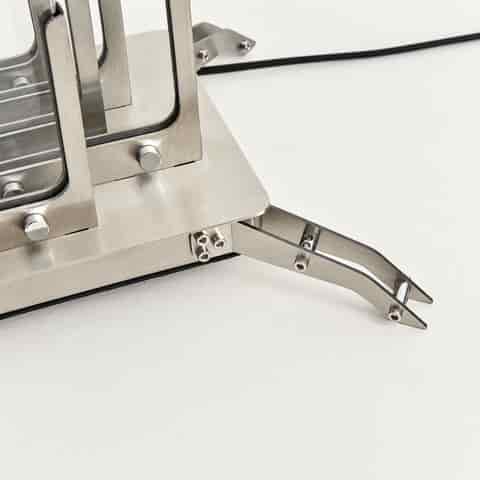 Close up of the brushed metal base and curved support feet of a geometric glass LED table lamp