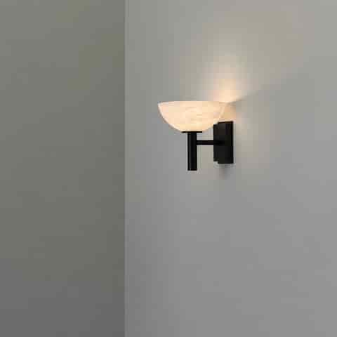 Black alabaster wall sconce with warm diffused ambient lighting