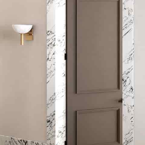 Gold finish alabaster wall sconce installed beside a modern entryway