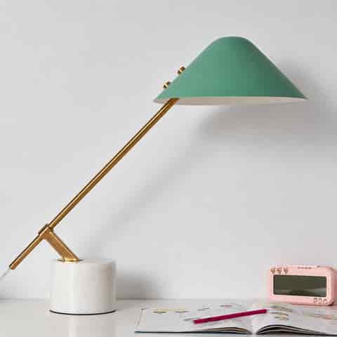 Green cantilever table lamp with a natural stone base, polished gold metal arm and geometric conical shade