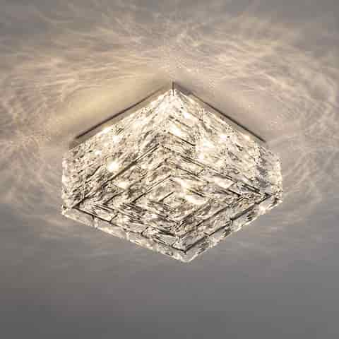 Modern square crystal ceiling light with layered faceted panels and a polished metal frame in a contemporary interior