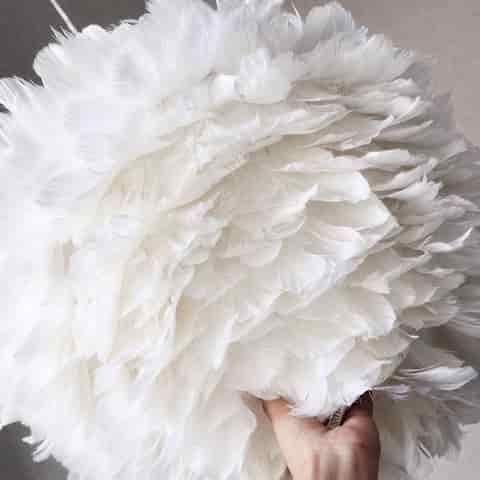 Close up of layered white feather texture on a decorative pendant light shade